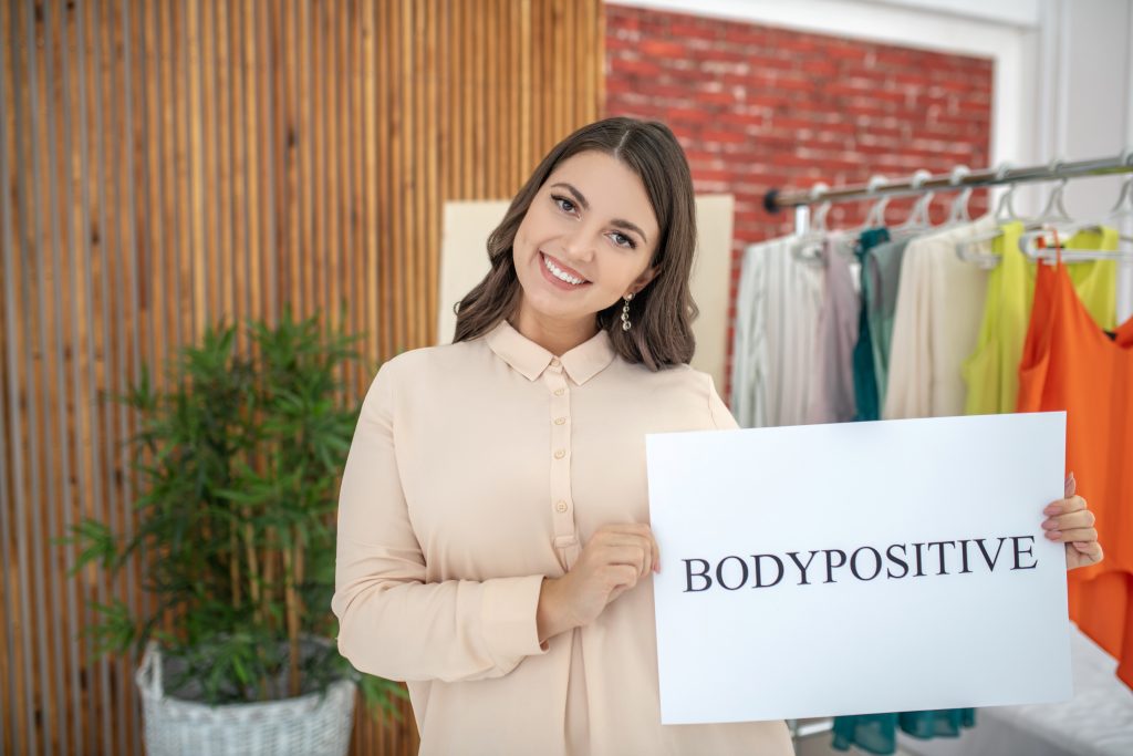 Young woman in a beige blouse looking happy